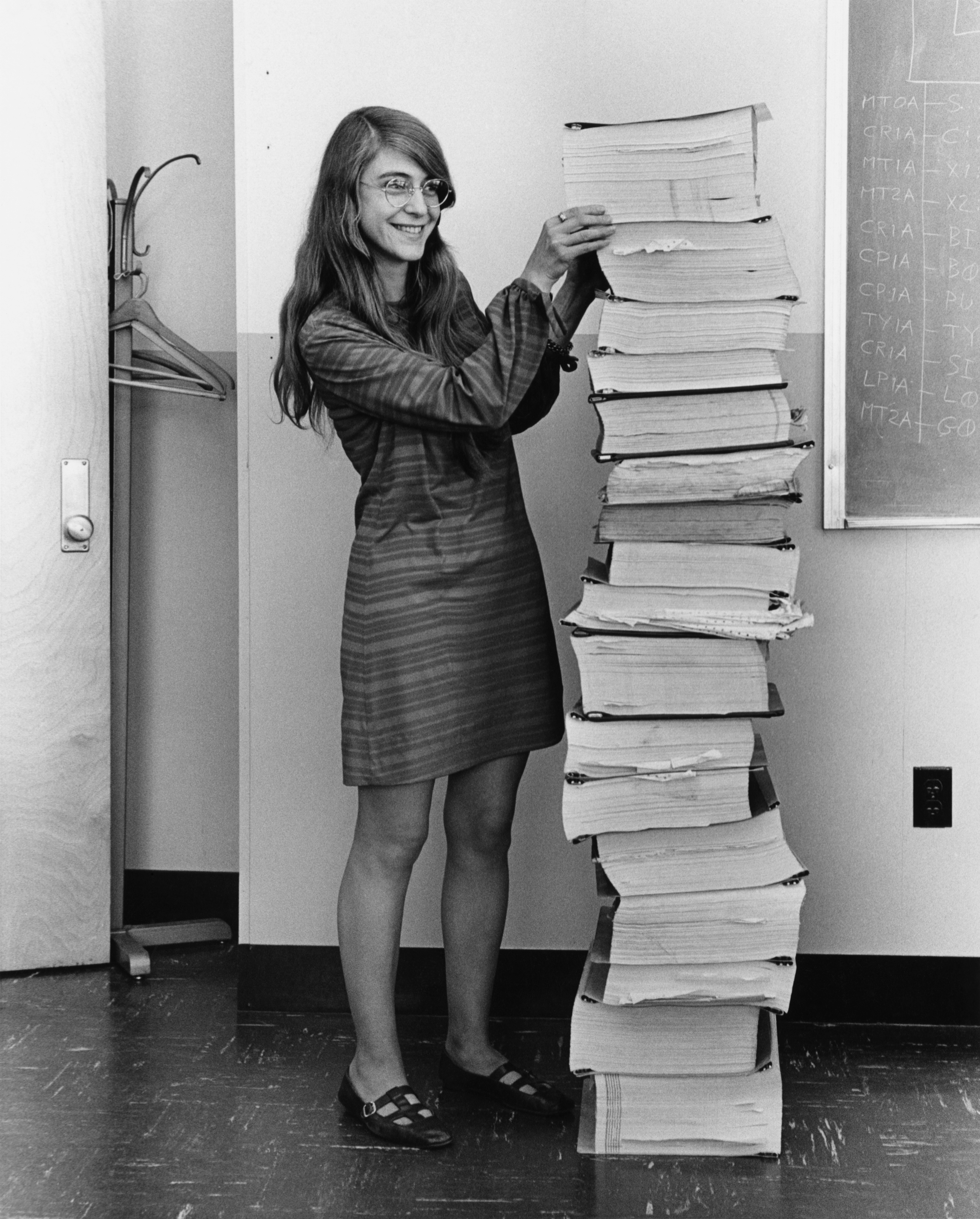 Margaret Hamilton à côté du code du logiciel de navigation